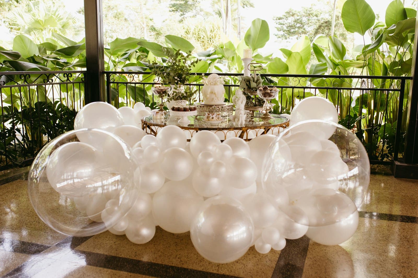 An elegant white and clear balloon installation styled for a celebration